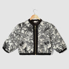 Jacket with black and white floral pattern on a hanger against a light gray background