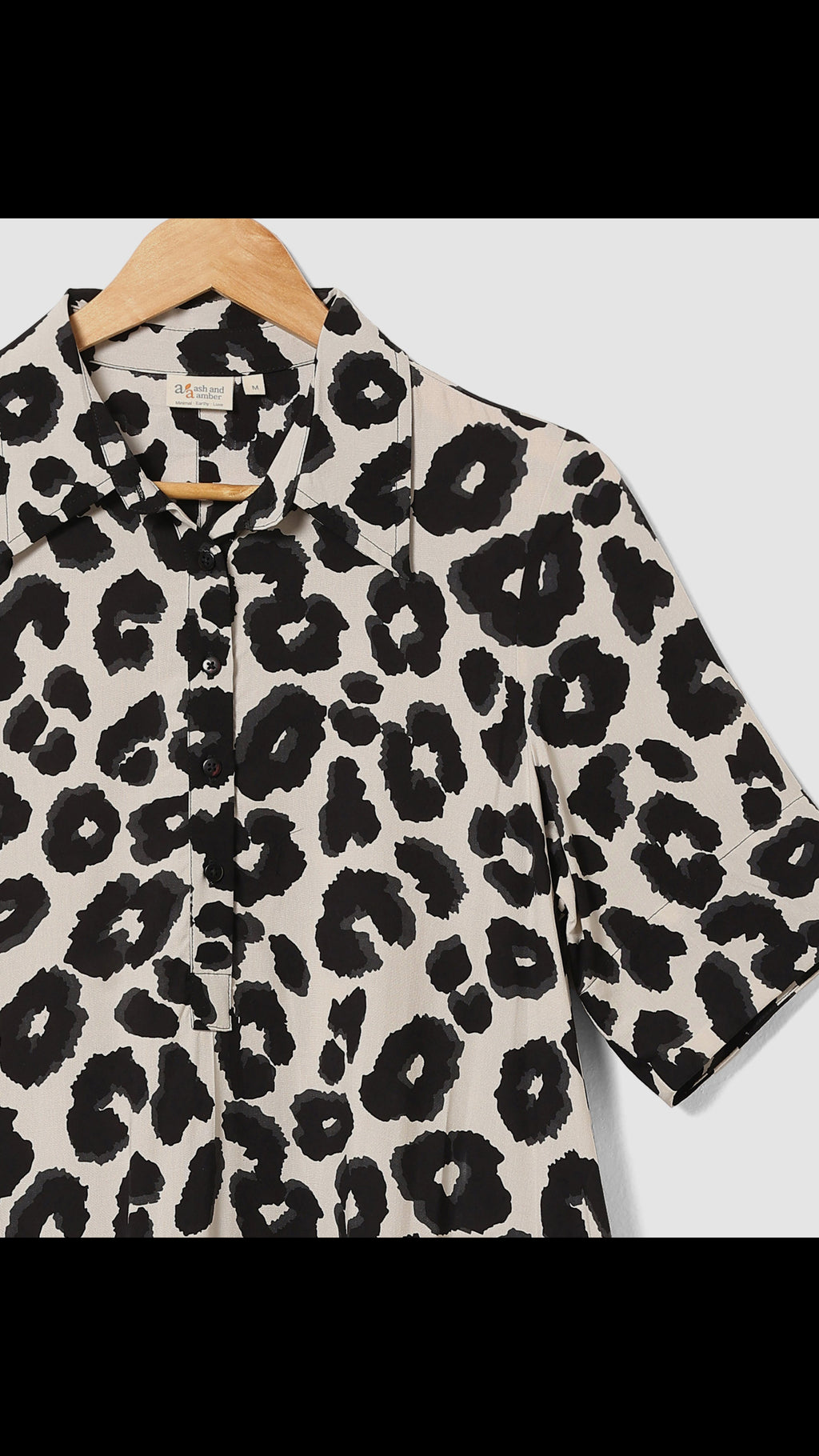 Leopard print shirt on a hanger with a white background