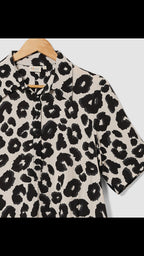Leopard print shirt on a hanger with a white background