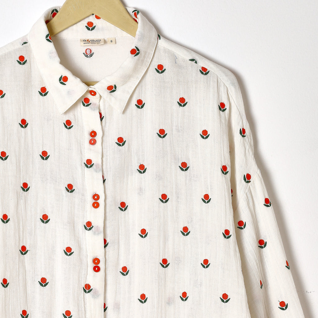 White shirt with red floral pattern on a white background