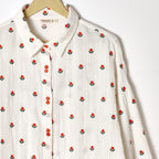 White shirt with red floral pattern on a white background
