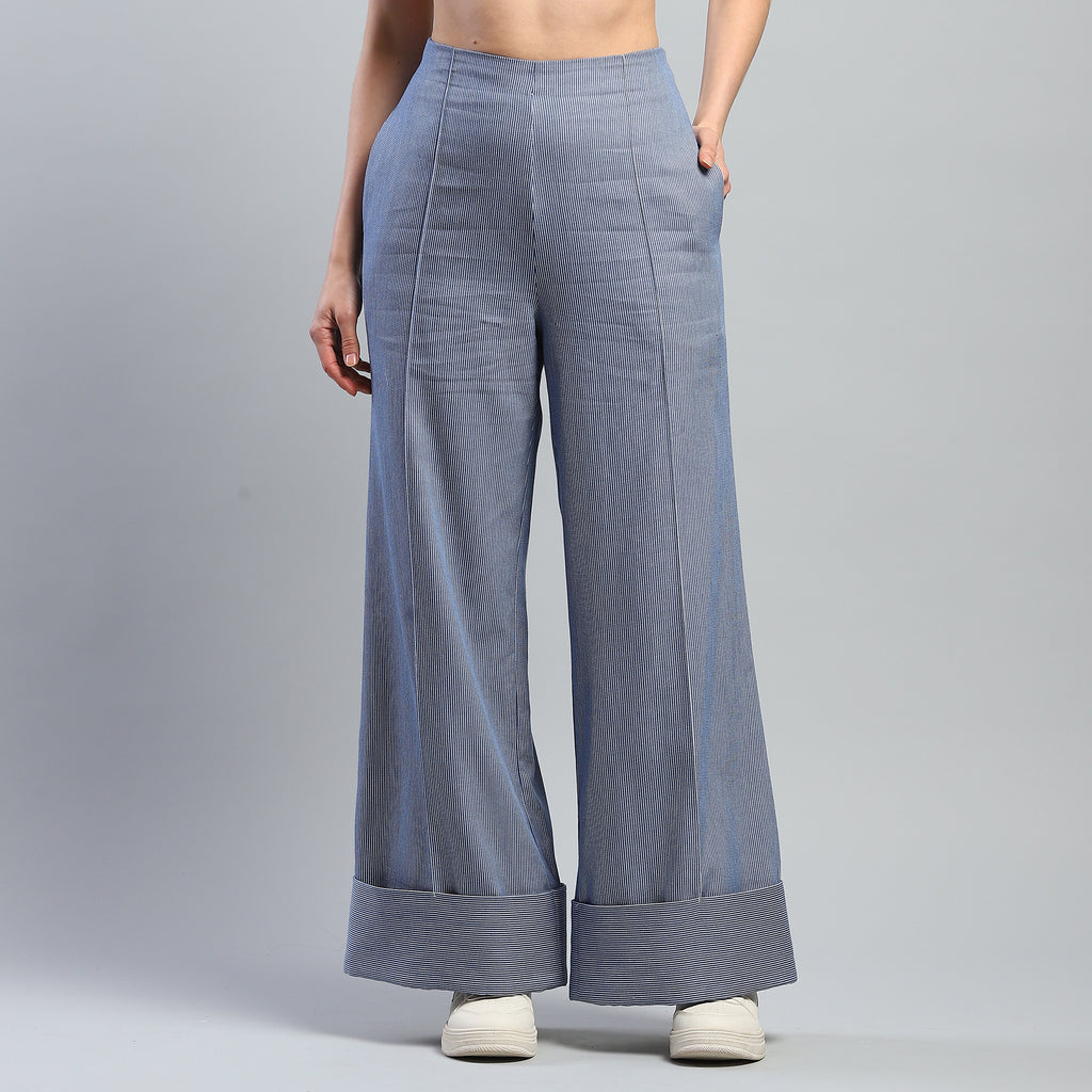 Person wearing light blue wide-leg pants on a gray background