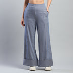 Person wearing light blue wide-leg pants on a gray background