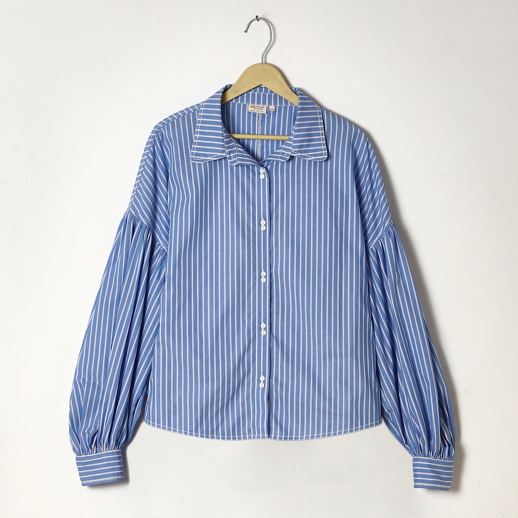 Blue and white striped shirt on a hanger against a white background