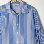 Blue and white striped shirt on a hanger against a white background