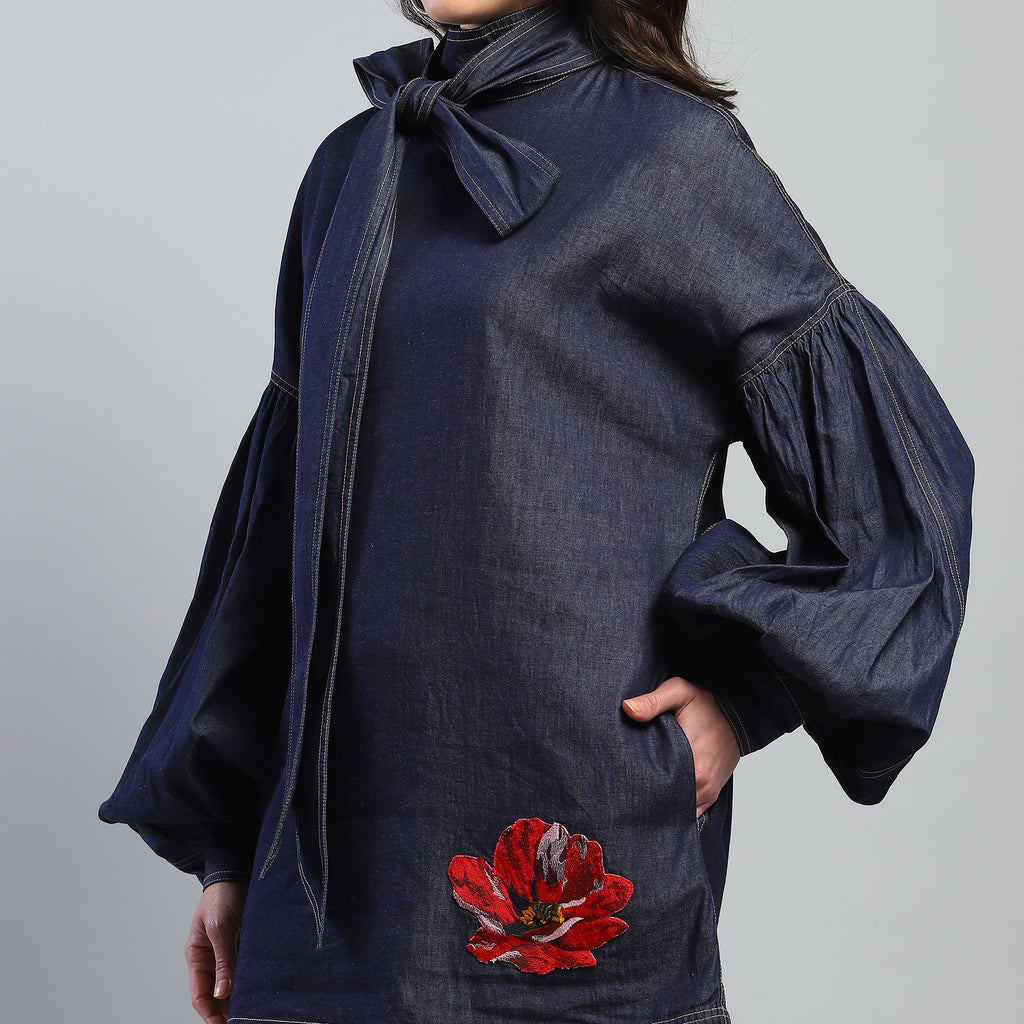 Navy blue dress with red floral embroidery on a plain background