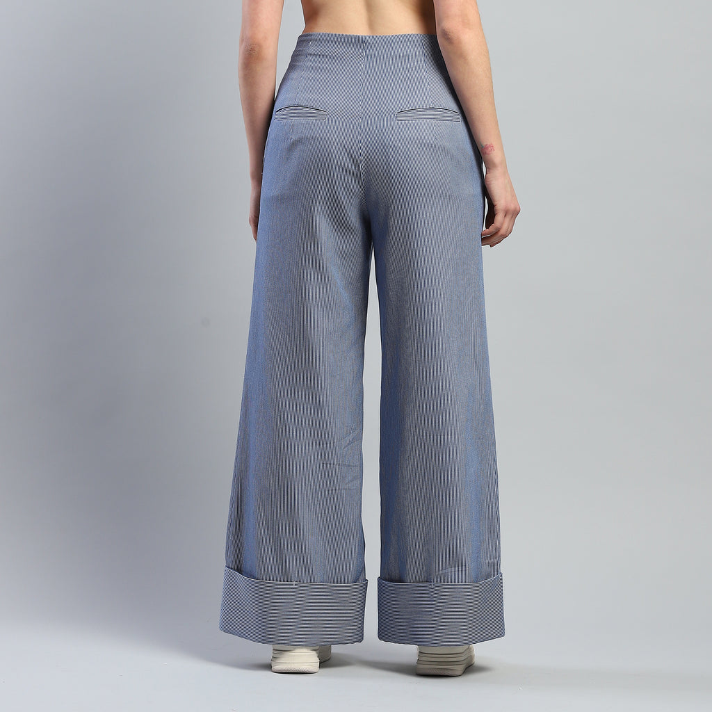 Person wearing blue wide-leg pants on a gray background