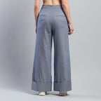 Person wearing blue wide-leg pants on a gray background