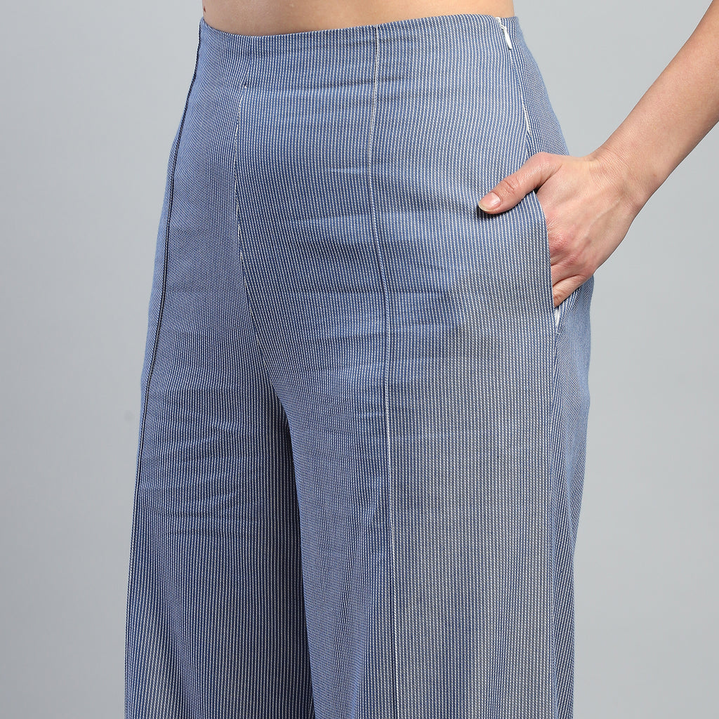 Blue checkered pants worn by a person on a gray background