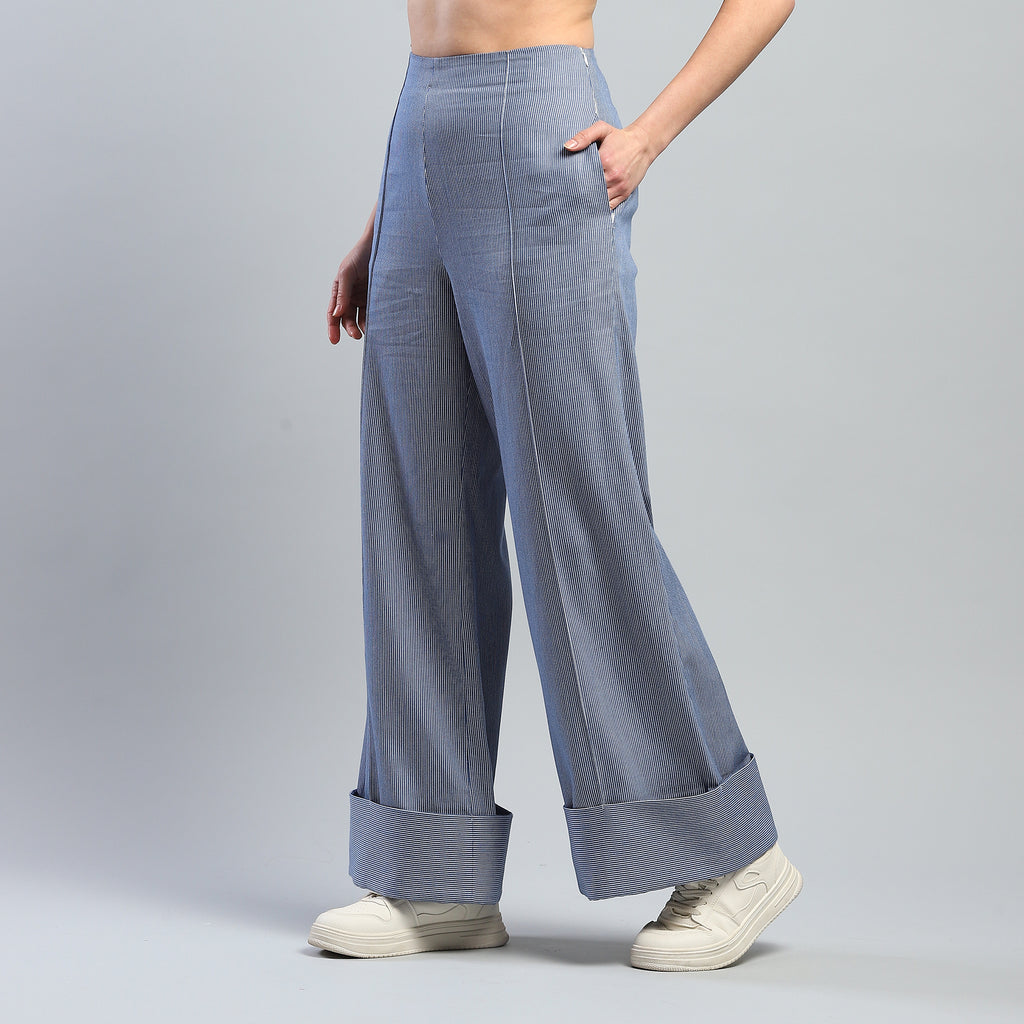Person wearing light blue wide-leg pants on a gray background