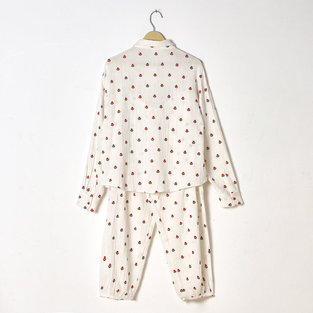 White pajama set with red polka dots on a white background