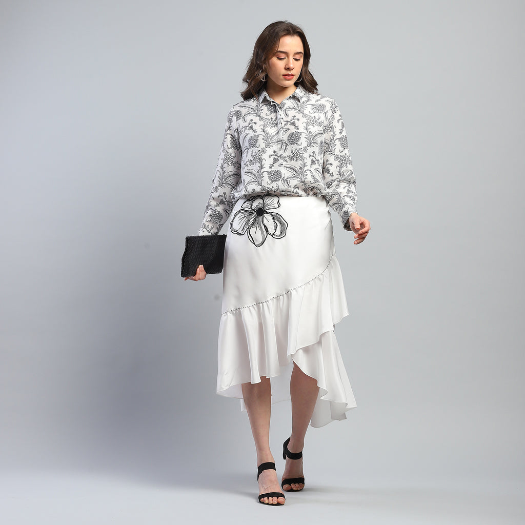 Tarani Skirt in 100% pure silk featuring an asymmetrical silhouette with cascading layers, contrast stitching, and delicate floral embroidery, styled on model.